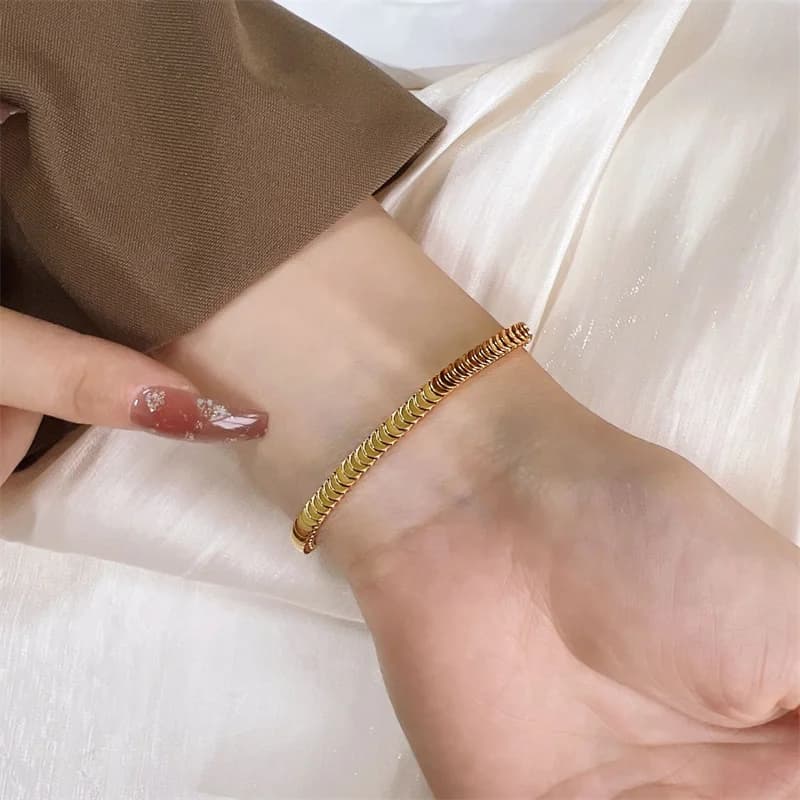 Sæt med guldfarvet slangekæde halskæde og armbånd