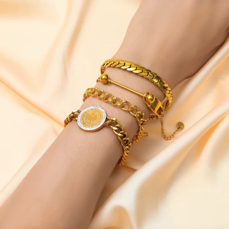 Sætte med fladt bredt kædehalssmykke og armbånd i guld