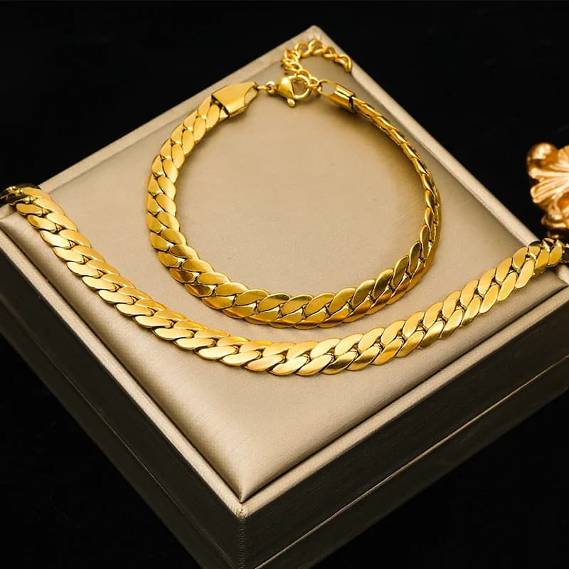 Sætte med fladt bredt kædehalssmykke og armbånd i guld