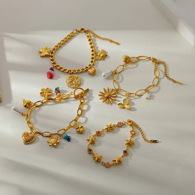 Guldfarvet armbånd med flere charms